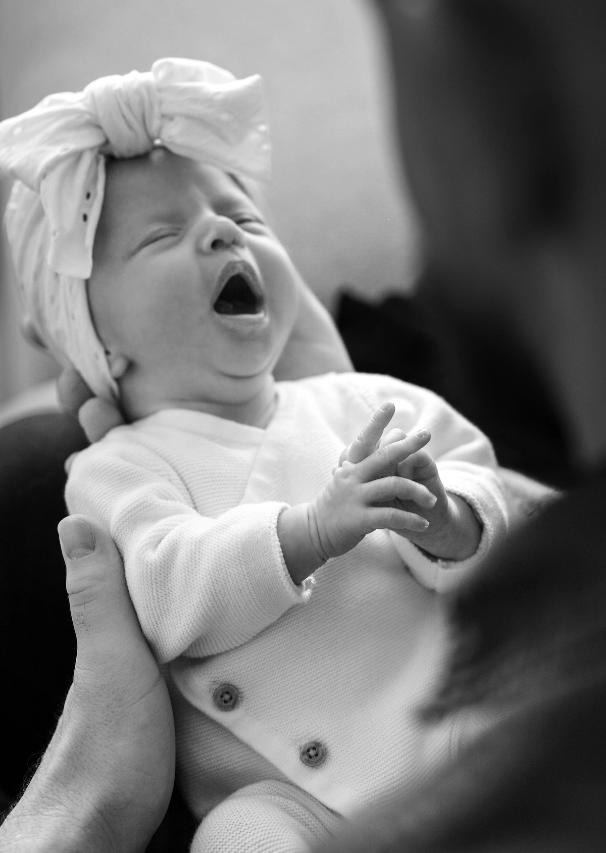 Bébé qui bâille dans les bras